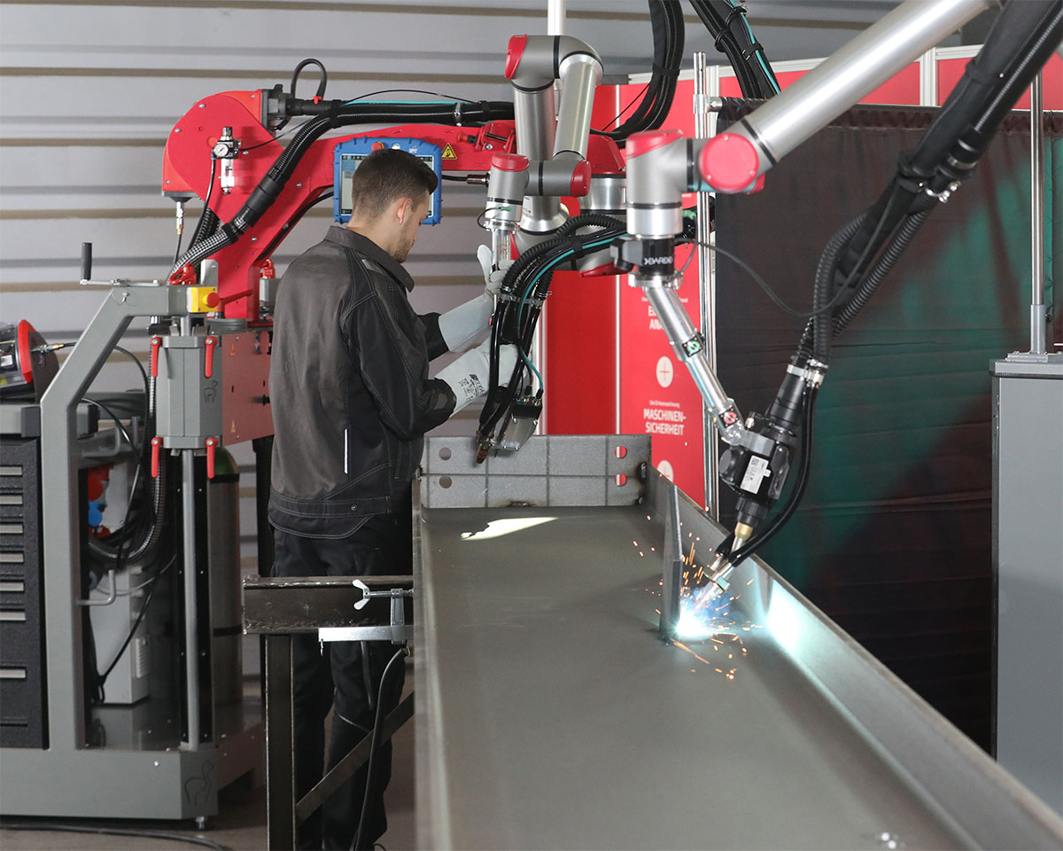 Zwei ALPAKA Schweißcobots arbeiten direkt an einem großen Bauteil
