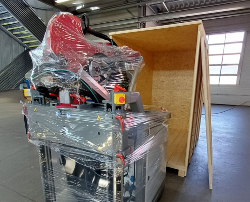 Verpackter Alpaka Schweißcobot vor der Transportkiste in der Werkhalle